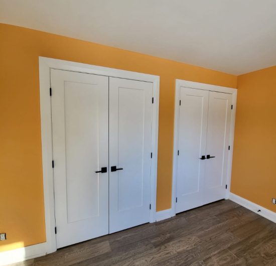 Construction worker standing on wooden beams, aligning and securing roof trusses during house framing.