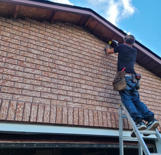 Modern garage renovation with epoxy flooring, white cabinetry, and overhead storage by Prime Built Construction.