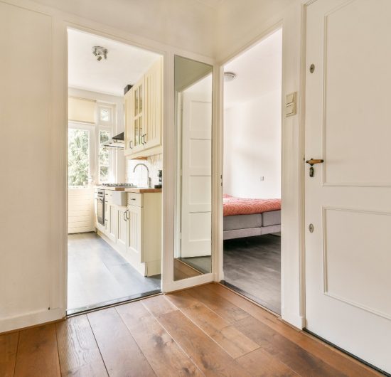 Bright modern kitchen with large island, pendant lights, and white cabinetry by Prime Built
