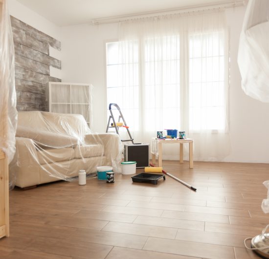 Close-up of a craftsman’s hand carefully applying finishing touches to wood trim.